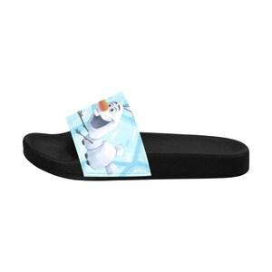 May include: Black slide sandal with a cartoon image of Olaf from Frozen on a light blue background. The sandal has a textured sole and a single strap across the top of the foot.