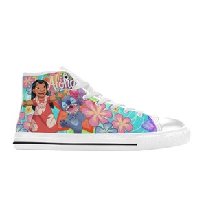 Puede incluir: Zapatillas altas de lona con un dise&ntilde;o colorido con los personajes Lilo y Stitch, rodeados de flores tropicales. Las zapatillas tienen una puntera blanca, cordones y suela con una franja negra.