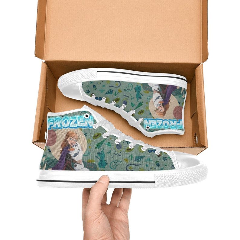 Może przedstawiać: Wysokie trampki pł&oacute;cienne z białą gumową podeszwą i sznurowadłami. Trampki mają turkusowe tło ze wzorem płatk&oacute;w śniegu i postaci z filmu "Frozen". Słowo "FROZEN" jest nadrukowane z boku.