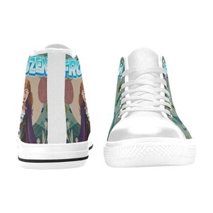 Może przedstawiać: Białe wysokie trampki z motywem Frozen. Trampki wyświetlają słowo "Frozen" w kolorze niebieskim i zielonym, wraz z obrazami postaci. Mają białe sznurowadła i podeszwy.