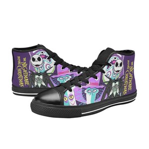 May include: High-top canvas trainers featuring characters from "The Nightmare Before Christmas." The shoes have a black toe cap, black laces, and a purple and black design with the movie title. The design includes Jack Skellington and other characters.