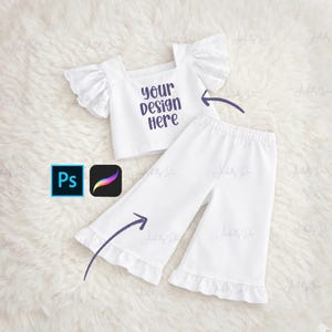 May include: White two-piece outfit with a square neckline top and flared trousers. The top features ruffled sleeves with eyelet detailing. The trousers have a ruffled hem. The text "your design here" is printed on the top.