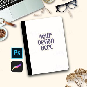 Pode incluir: Um caderno branco com lombada preta e o texto "your design here" em roxo. A imagem também inclui um laptop, óculos, clipes de papel, um relógio e ícones de software de design.