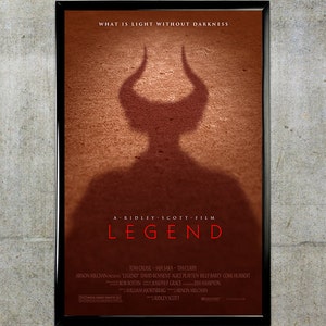 Puede incluir: Un póster de película para la película "Legend" protagonizada por Tom Cruise, Mia Sara y Tim Curry. El póster presenta una gran figura roja y sombría de un demonio cornudo con el título de la película en grandes letras blancas.