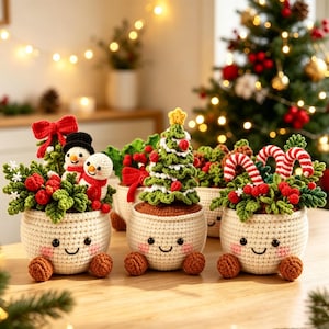 May include: Three crocheted pots with smiling faces, each containing festive decor. One holds snowmen and a red bow, another a green Christmas tree with a yellow star, and the third features red berries and two red and white striped candy canes.