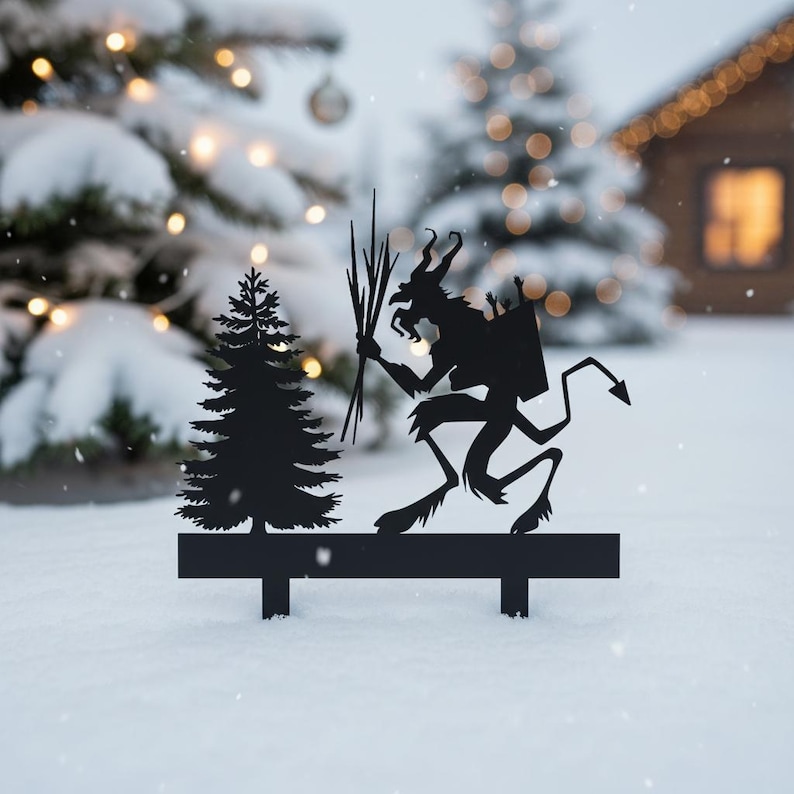 May include: Black metal silhouette of a Krampus figure with a fir tree. The Krampus is holding birch branches and has a sack on its back. The scene is set in a snowy winter landscape with a blurred background of Christmas trees and a house.