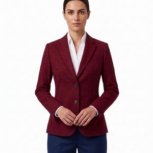 May include: A burgundy blazer with a two-button closure, paired with a white collared shirt and navy blue trousers. The blazer has a tailored fit and is made of a textured fabric, suitable for professional or formal wear.