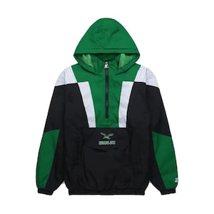 May include: Green, black, and white hooded anorak jacket. The jacket features a green hood, a black body, and white accents. The front pocket displays the text "EAGLES" and a logo. The jacket has a zipper closure and is made by Starter.