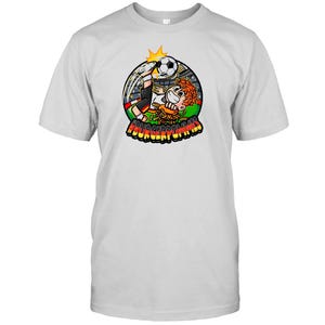Può includere: Una t-shirt grigio chiaro a maniche corte con una grafica circolare di un personaggio dei cartoni animati che calcia un pallone da calcio su un hamburger. Il design include un pallone, uno stadio e il testo #BURGERPOMMES in lettere gialle.