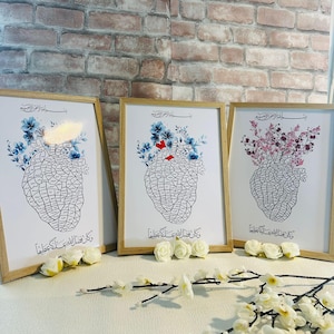 May include: Three framed art prints featuring a heart-shaped anatomical diagram filled with text. Each print has a different floral arrangement in blue, red, and pink. The frames are light brown, and the prints are displayed on a white surface.