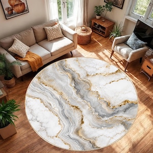 May include: A large circular area rug featuring a marbled pattern with swirling veins of white, grey, and metallic gold. The design mimics natural stone textures, creating a fluid, abstract aesthetic across the entire surface of the round floor covering.