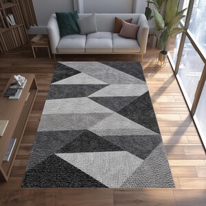 Alfombra geométrica abstracta: Alfombra triangular negra y gris, estampado monocromático moderno, estilo de decoración minimalista contemporáneo.