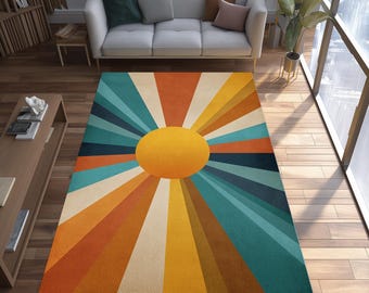 May include: A retro-style area rug featuring a large yellow sunburst design. The rug has a vibrant color palette of orange, teal, and cream, creating a bold and eye-catching statement piece for any living space.