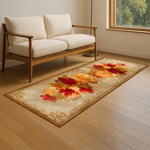 Puede incluir: Alfombra rectangular con un diseño de hojas de otoño en tonos rojos, naranjas y amarillos. La alfombra tiene un fondo beige y un borde dorado decorativo. Está colocada sobre un suelo de madera.