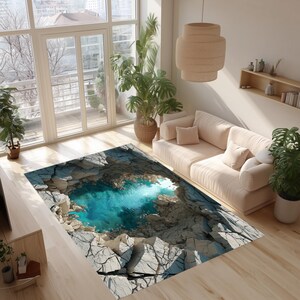 Può includere: Un tappeto rettangolare con una rappresentazione 3D di una piscina turchese circondata da formazioni rocciose grigie e screpolate. Il tappeto si trova in un soggiorno con un divano beige, piante e grandi finestre.