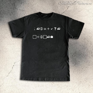 May include: Black t-shirt featuring white graphic symbols. The symbols include a question mark, a check mark, a gift box, and other shapes. The shirt is made of a soft material and has a crew neck.