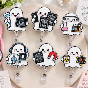 May include: Six white ghost-shaped badge reels featuring medical themes. One holds an ultrasound, one an X-ray, one lab equipment, one a CT scanner, one a brain scan with a magnet, and one a coffee mug with a radiation symbol and an atom model.