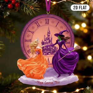 May include: A round Christmas ornament featuring a princess in an orange gown and a witch in a purple dress. The background is a clock face with a castle. The ornament has the text "2D FLAT" and "Your Custom Text".