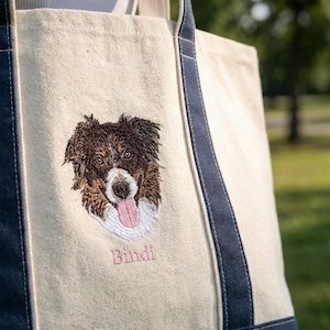 Detailed shot of a canvas boat tote in natural/Navy featuring bespoke dog face embroidery. The textured canvas and premium stitching highlight the quality of this customized Liberty Bags 8871, a top-selling personalized tote bag for dog lovers.