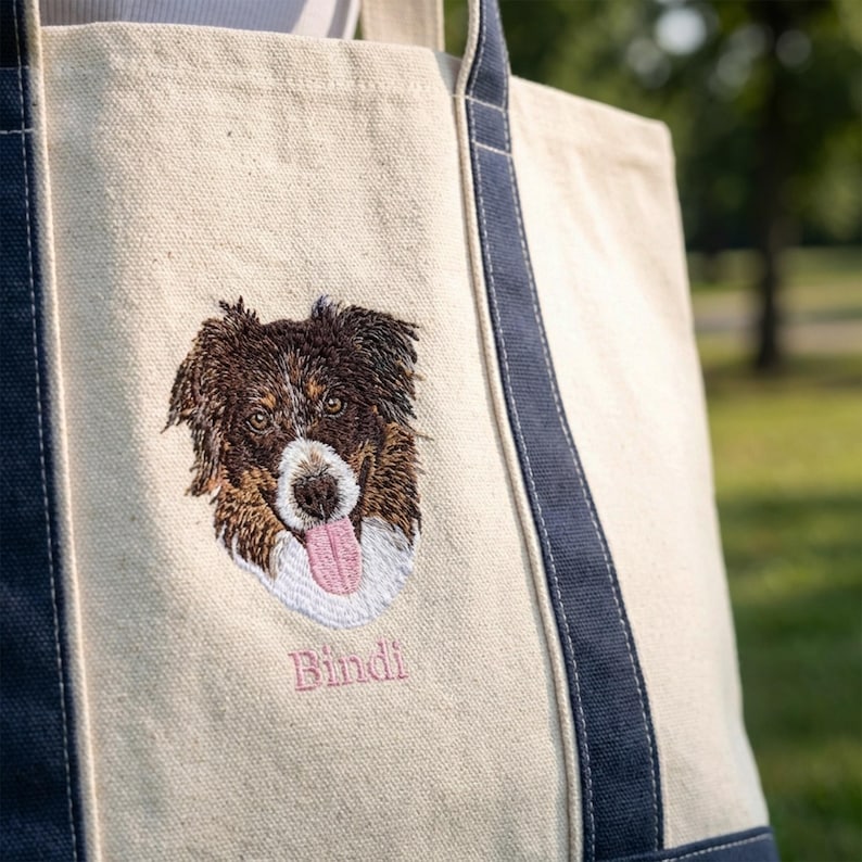 Detailed shot of a canvas boat tote in natural/Navy featuring bespoke dog face embroidery. The textured canvas and premium stitching highlight the quality of this customized Liberty Bags 8871, a top-selling personalized tote bag for dog lovers.