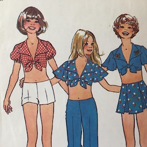 May include: Three illustrations of women wearing different crop tops with a tie at the front. The crop tops are red with white polka dots, blue with white flowers, and blue with white stars. The women are wearing white shorts, blue pants, and a blue skirt.