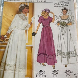 May include: A Burda 9447 sewing pattern envelope featuring three dress designs. Design A is a long-sleeved white dress with lace trim. Design B is a short-sleeved white dress with a veil and lace hem. Design C is a short-sleeved magenta dress.