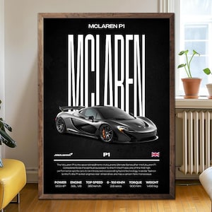 May include: A framed poster featuring a black McLaren P1 sports car. The poster has the word "McLaren" in large white letters, with the car's name and specifications below. The car is dark gray with orange brake calipers.
