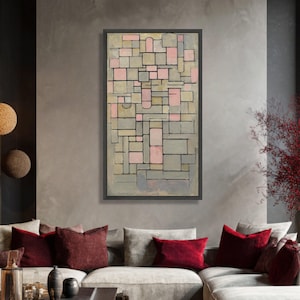 Könnte beinhalten: Abstrakte geometrische Kunst in einem schwarzen Rahmen. Das Kunstwerk zeigt eine gitterartige Komposition aus rechteckigen und quadratischen Formen in Grau-, Rosa- und Beigetönen. Es hängt über einem grauen Sofa mit roten Kissen und schafft ein modernes Interieur.