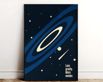 May include: A framed art print depicting a black hole in space, rendered in shades of blue and white against a dark backdrop. The print includes the text: "Less gravity. More wonder."