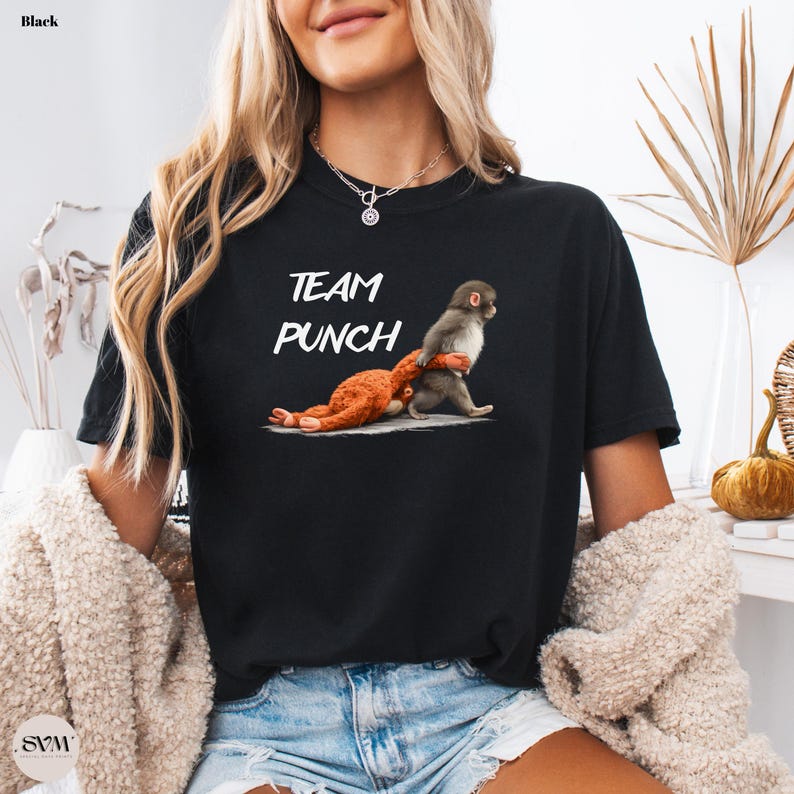 May include: Black t-shirt with the text "TEAM PUNCH" in white. The graphic depicts two monkeys, one punching the other. The shirt is made of a soft material.