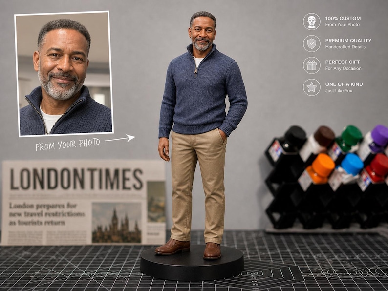 May include: A custom figurine of a man in a blue sweater and khaki pants, standing on a black base. The image includes a framed photo and text that reads "FROM YOUR PHOTO." The background features a newspaper and a rack of colorful bottles.