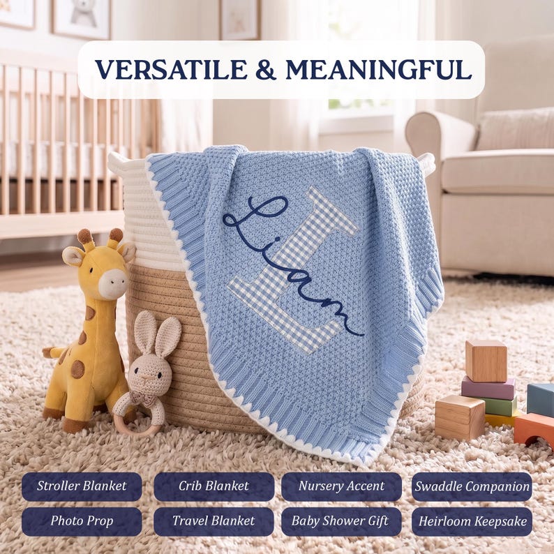 May include: A light blue knit baby blanket featuring a large white and blue gingham letter L with the name Liam embroidered in dark blue script. The blanket is draped over a woven basket next to a plush giraffe and a small crocheted rabbit toy.