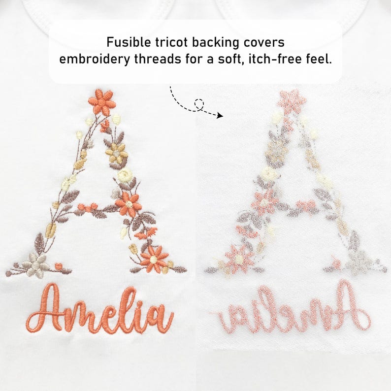 May include: White fabric featuring embroidered floral letter "A" and the name "Amelia" in orange thread. The text "Fusible tricot backing covers embroidery threads for a soft, itch-free feel" is also visible.