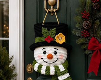 Peut inclure: Une décoration de porte en crochet représentant un bonhomme de neige avec un haut-de-forme noir orné d'un ruban vert, de feuilles, de baies rouges et d'une fleur jaune. Il possède un visage blanc, des yeux noirs, un nez orange et une écharpe rayée.