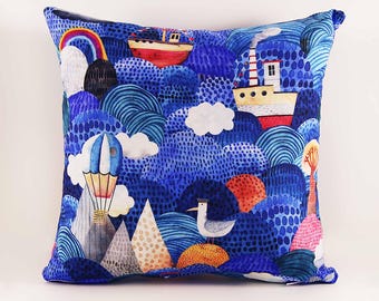 May include: A square throw pillow featuring a vibrant blue landscape illustration with rolling hills, a red and white boat, a hot air balloon, a white seagull, and a rainbow. The design includes textured patterns of dots and lines throughout.