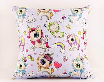 May include: A square throw pillow featuring a repeating pattern of cartoon unicorns on a white background. The unicorns have colorful manes, golden horns, and wings, interspersed with small pink hearts, rainbows, stars, clouds, and diamonds.