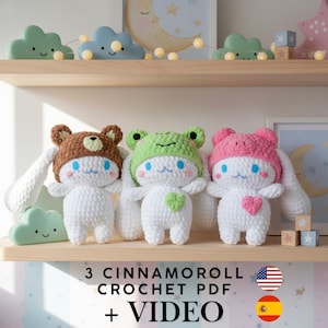Peut inclure: Trois peluches Cinnamoroll crochetées blanches, chacune portant un chapeau différent : un ours brun, une grenouille verte et un lapin rose. Le texte "3 Cinnamoroll Crochet PDF + VIDEO" est affiché en dessous.
