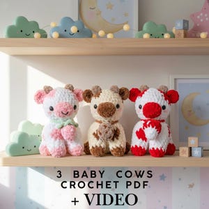 Peut inclure: Trois peluches de vaches pour bébés au crochet faites à la main, en blanc, rose, marron et rouge, disposées sur une étagère en bois. Le texte "3 BABY COWS CROCHET PDF + VIDEO" est affiché en dessous. Des lumières nuages décoratives et des œuvres encadrées sont en arrière-plan.