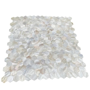 Op de afbeelding: Een vel iriserende, zeshoekige tegels. De tegels zijn voornamelijk wit met subtiele kleurvariaties, waaronder tinten beige en roze. De tegels zijn gerangschikt in een rasterpatroon, geschikt voor gebruik als decoratief oppervlak.