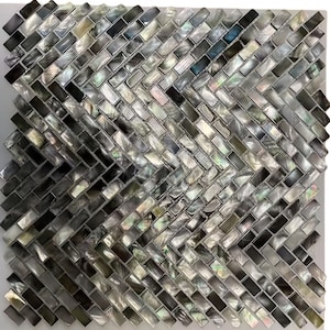 Peut inclure: Carreau de mosaïque carré avec un motif en chevrons. Les carreaux rectangulaires présentent un mélange de couleurs irisées, dont le noir, le gris et des reflets nacrés. Idéal pour les projets de design d'intérieur.