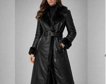 May include: A long black leather coat with a faux fur collar, cuffs, and trim. The coat features a belt at the waist, a zipper closure, and pockets. The coat is a stylish outerwear garment.