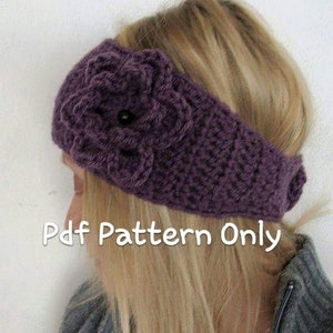 Può includere: Fascia per capelli in crochet viola con un dettaglio floreale. La fascia è realizzata con un punto a trama e ha un bottone nero al centro del fiore.  Pdf Pattern Only.