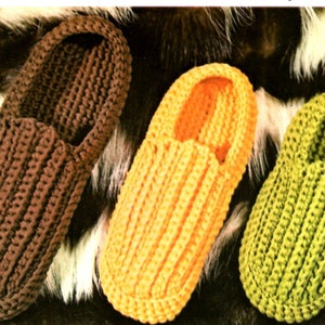 Puede incluir: Tres zapatillas de crochet en marrón, naranja y verde. Las zapatillas están hechas con un punto sencillo y tienen una punta puntiaguda.