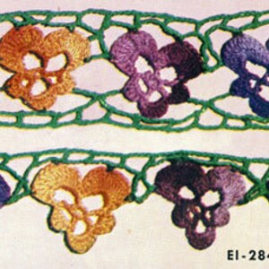 Op de afbeelding: Een gehaakte rand met een herhalend patroon van paarse, oranje en groene viooltjes. De rand is gemaakt van groen haakgaren en heeft een delicaat, kantwerkontwerp.