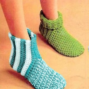 Puede incluir: Un par de zapatillas de crochet. Una zapatilla es verde y la otra es azul y blanca a rayas.