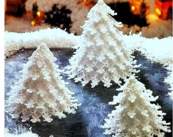 Puede incluir: Tres árboles de Navidad de ganchillo blanco sobre un fondo azul y blanco. Los árboles están hechos de encaje delicado y tienen un aspecto nevado.