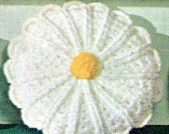 May include: White crocheted daisy flower with a yellow center. The flower is about 4 inches in diameter.