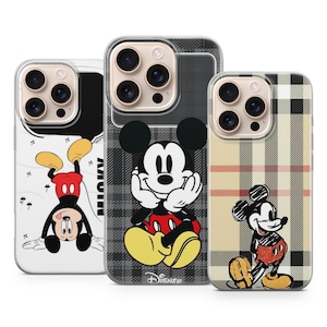 May include: Three phone cases with Mickey Mouse designs. One case shows Mickey upside down, another has Mickey against a grey plaid background, and the third has Mickey in a standing pose with a beige plaid pattern. All cases have a clear border.