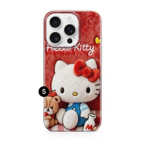 May include: A red phone case featuring Hello Kitty. The case has a fuzzy texture and a cartoon image of Hello Kitty wearing a blue outfit and a red bow. A teddy bear and a milk bottle are also featured.
