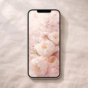 Puede incluir: Un smartphone blanco muestra un fondo de pantalla floral con peonías rosas y capullos. Las flores están en plena floración, con delicados pétalos y hojas verdes. El fondo es de un rosa suave y borroso, creando una estética romántica.